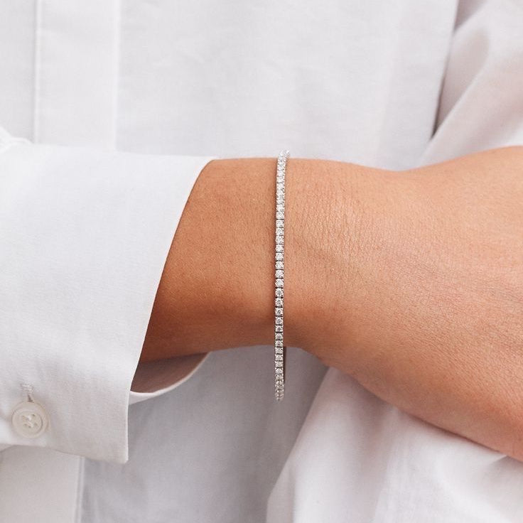 Delicate 2mm lab diamond tennis bracelet worn on wrist in soft morning light