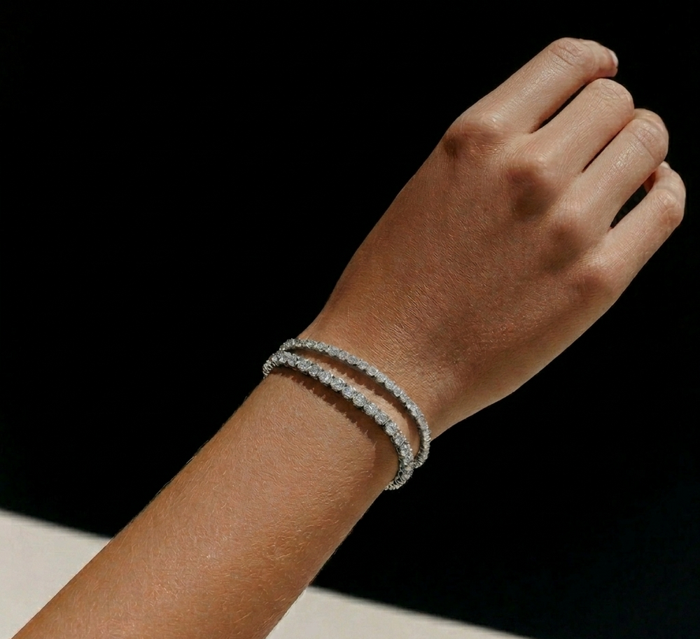 Woman wearing layered 2mm lab diamond tennis bracelet stack in lifestyle plain setting