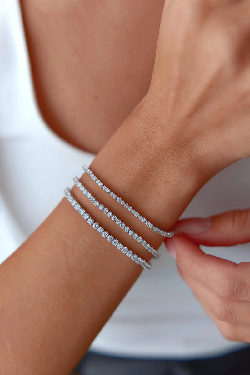 Close-up of woman's wrist wearing 2mm lab created diamond tennis bracelet at home