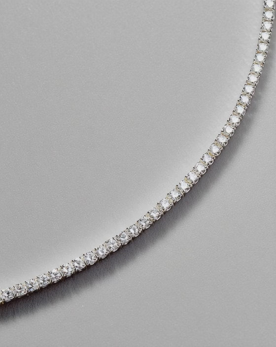 2mm lab stone tennis bracelet catching golden hour light on woman's wrist